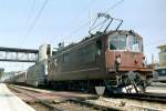 Re 4/4 167 und Re 465 warten mit einem Korridorzug im Bahnhof von Spiez auf die Abfahrt Richtung Domodossola.August 2003