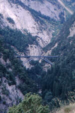 Eine der markantesten Eisenbahnbrücken Europas ist die Bietschtalbrücke der BLS. Eine knappe Stunde ist man vom Bahnhof Raron aus unterwegs bis zu ihr. Über sie führen nicht nur die beiden Gleise der Lötschberg-Südrampe, sondern auch ein Fußgängerweg. Als das Foto 1988 entstand, war der Ausbau der Lötschbergbahn zur Doppelspur mit Profilerweiterung in vollem Gange. 2007 wurde der meist einspurige Lötschberg-Basistunnel eröffnet.
Raron im Wallis, 29. Juni 1988; Canon AE-1, Canoscan, Gimp