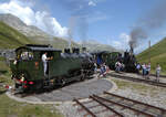 Harte Arbeit! Lok HG 4/4 704 wird in der Station Furka (2160 müM) auf der Drehscheibe abgedreht, währenddem im Hintergrund der Kreuzungszug wartet.