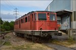 Trauriges Ende einer grande Dame in Kaiseraugst, Ae 6/6 11455  Biel . Juli 2016. 

Bild von öffentlichem Fussweg zum Bahndurchlass.