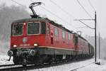 Re 420 322-0 ist zusammen mit Re 6/6 11617  Heerbrugg  am 27.02.2020 bei winterlichen Verhältnissen mit einem Güterzug auf der Bözbergrampe bei Schinznach-Dorf unterwegs in Richtung