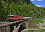 Eine Re 10/10 mit einem Güterzug am 20.05.2016 bei Faido.