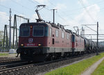 SBB: Gegenlichtaufnahme der Re 4/4 II 420 278-4 mit dem Wappen  CHAM  vor einem Kesselwagenzug in Richtung Westschweiz unterwegs bei Deitingen am 4.