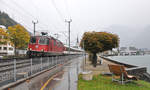 Nicht immer zeigt sich das Wetter von seiner schönen Seite. Bei trüben und regnerischen Bedingungen fährt die Re 4/4 II 11194 mit einem Interregio aus dem Bahnhof Flüelen. 14.10.2016