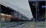 Die SBB Re 4/4 II 11109 Swiss-Express wartet mit ihrem IR 3028 nach Brig bei zu dieser Nachtmittagszeit ungünstigen Lichtverhältnissen auf die Abfahrt.