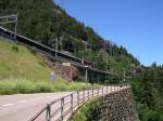 125 Jahre Gotthardbahn - Cirka 10 bis 15 min nach dem EuroCity bzw. dem Cisalpino folgt der Interegio nach Locano in Richtung Sden. An der Passstrae zum Susten berquert am 07.07.2007 IR 2173 Basel - Locarno die Mittlere Maienreussbrcke. Die Fahrt durch den anschlieenden Kehrtunnel dauert ca. eine Minute und der Zug erscheint in entgegengesetzter Fahrtrichtung noch einmal oberhalb dieser Fotostelle. Vorsicht beim Fotografieren an dieser Stelle, die Passstrae ist sehr stark befahren! Vor allem die Tfflifahrer jagen in halsbrecherischer Art bergwrts!