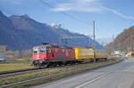 Donnerstag den 05.01.2023 Uhr um 14:16 Uhr. Nördlich vom Bahnhof Castione-Arbedo bei der Linkskurve (in nördlicher Richtung gesehen) auf der Seite des Einkaufszentrums gibt es den Gehsteig welcher eine kleine Stützmauer besitzt. Auf dieser Mauer kann man stehen und erreicht somit eine Höhe dass die vorbeikommenden Autos die Sicht zum Bahndamm nicht behindern. Vom Norden kommt die Re 4/4 II (Re 420) mit der Fahrzeugnummer 91 85 4420 294-1 CH-SBBC mit der Jubiläumsbemalung „100 Jahre Schweizer National Zirkus Knie“ (1919 – 2019) und dem Wappen von St. Gallen da sich der Heimatort des Zirkus Knie in Rapperswil (SG) befindet. Am Zughacken hat er zwei Postwagen angehängt.