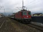 Re 4/4 11112 mit einem Reisezug in Brunnen.