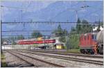 Re4/4 II 11257 holt einen Zementzug in Untervaz-Trimmis ab und S1 1525 ist auf dem Weg nach Chur. (28.06.2010)