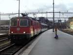 Die Re 4/4  11219 schiebt am 05.12.2011 einen soeben aus dem Tessin berfhrten TILO-Bt in die Luzerner Depot-Gleise. Das Sonnenlicht, das auf die rechte Lokseite reflektiert wird, kam ber die EW III (rechts knapp zu erkennen).