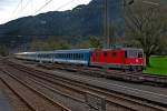 Re 4/4 11208 kommt am verlassenen Bahnhof Weesen vorbei mit dem Nachtzug aus Budapest nach Zürich HB.Bild vom  7.10.2014