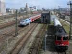 Whrend SBB CFF FFS Cargo 421 383 mit einem rail-adventure-Wagen auf neuen Einsatz wartet, schiebt Bgelfalte 111 031 (Olympia-Lok) einen Regio zum Hauptbahnhof; aufgenommen von der Donnersbergerbrcke, Mnchen, 05.04.2011
