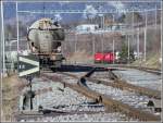 Braunkohlestaub-Wagen der VTG Hamburg mit deutschen Zugschlusssignalen in der bergabegruppe der Holcim Zementwerke Untervaz. Ein Interregio mit Re 460 rauscht unter der RhB Brcke hindurch Richtung Landquart. (09.02.2007)