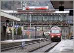 Eine Re 460 fhrt in den Bahnhof Arth-Goldau ein, whrenddem darber in der Passarelle der Triebwagen Nr. 14 der Rigibahnen auf Fahrgste wartet. Wegen des Regenwetters sind wir allerdings nur zu dritt. (12.02.2007)