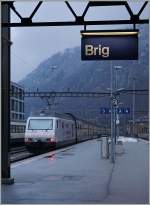 Die SBB Re 460 052-4  Gotthardo  verlässt, ihren IC 811 nach Romanshorn Richtung Bern schiebend, den Bahnhof Brig.
19. Feb. 2016