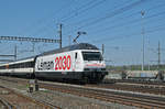 Re 460 075-5, mit der Léman 2030 Werbung, durchfährt den Bahnhof Muttenz.