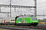 Re 460 080-5, mit der Migros Werbung, durchfährt bei Regenwetter den Bahnhof Muttenz.