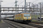 Re 460 029-2, mit der Chiquita Werbung, durchfährt den Bahnhof Muttenz.
