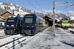Der GPX Zug 3  Gstaad  der nach Montreux abfährt, der GPX 2  Interlaken  der nach einer Fahrzeugstörung auf dem Gleis 5 steht und die Re 465 008 mit der Komp 4  Shania Train  der später wieder zurück nach Interlaken fährt, am 26.11.23 im Bahnhof Zweisimmen.