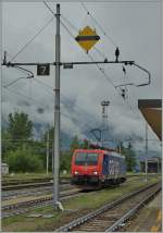 Die SBB Cargo Re 474 014 hinter dem Bügelsenksignal im Gleichstromteil von Domodossola.