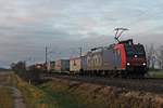 Re 482 004-9 am 23.12.2017, als sie mit einem Containerzug vor dem Sonnenaufgang bei Hügelheim durchs Rheintal in Richtung Norden fuhr.