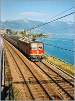 Die scheinbar erst vor kurzem rot gefärbte SBB Re 6/6 11636 Vernier Meyrin fährt mit dem EC  40  Monteverdi  von Venezia nach Genève kurz vor Rivaz am Genfersee entlang. Leider sind Bilder mit Re 6/6 geführten Reisezügen eher selten, weshalb ich mich entschlossen habe dieses Bild zu zeigen. Ein weiterer Grund ist natürlich auch die damals noch vorhanden zierliche Fahrleitung. 

Analog Bild vom 4. Juni 1996