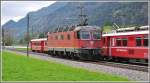 An gleicher Stelle bei Felsberg ist die Re 6/6 11619 unterwegs zu den Emser Werken und kreuzt die S2 1564. Hier ist deutlich der Grssenunterschied zwischen Normal- und Schmalspur sichtbar. (02.05.2012)