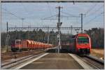 S5 nach Pfffikon SZ  mit Re 450 039-3 fhrt in Hntwangen-Wil ein. Die Re 6/6 11609  Uzwil  wartet mit einem beladenen Kieszug auf eine Lcke im dichten Fahrplan. (08.03.2013)