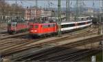 Verkehrte Welt. Der hochglanzpolierte DB-Oldie 115 114-1 leuchtet heftigst in Rot neben drei völlig verdreckten Re 6/6 der SBB Cargo. Singen, November 2015.