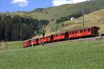 Das ist schon fast ein Bild f�r die Tourismuswerbung. Die Berglandschaft, Seilbahnmasten im Hintergrund und der Nostalgiezug passiert am 05.07.2026 ein Lichtsignal kurz vor der Einfahrt in die Station Dieni. 
Die Wagen wurden von Freiwilligen der DFB aufgearbeitet, einige Wagen stammen von der FO.