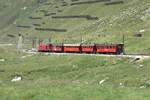 Der Sonderzug zum Jubil�um 100 Jahre FO hat am 05.07.2026 die Gallerie am Oberalppass verlassen und f�hrt jetzt Richtung Andermatt.
Im Hintergrund sind am Hang Lawinenverbauungen zu erkennen. Diese machen es m�glich, die Strecke meist auch im Winter zu betreiben. Die Strasse hingegen ist im Winter gesperrt.