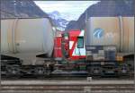 Normalspurige Zisternenwagen soeben aus dem Zementwerk Untervaz eingetroffen neben RhB WPersonenwagen in Landquart.