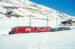 MGB FO-AUTOTRANSPORTZUG 4335 von Sedrun nach Andermatt am 15.02.1998 etwa 300m unterhalb Ntschen mit Zahnrad-E-Lok HGe 4/4II 105 - RhB B 2213 - Sklv 4833 - Rvw 4798 - Sklv 4834 - Sklv 4832.
