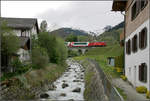 Gebirgsbach und Glacier-Express -    Ein Glacier-Express auf der Matterhorn-Gotthard-Bahn erreicht den Ort Disentis/Muster.