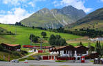 Zwischen Häusern und Bergbahn: Ein Zug der Matterhorn Gotthard Bahn in Sedrun am 04.08.2017.