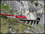 Lok 95 der Matterhorn Gotthard Bahn ist hier am 19.5.2025 um 10.32 Uhr auf Talfahrt nach Göschenen und erreicht gerade den Tunnel an der sogenannten Teufelsbrücke.