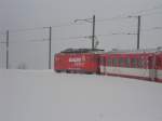Eine HGe 4/4 zieht einen Regionalzug von Disentis nach Andermatt �ber den tiefverschneiten Oberalppass am 23.02.2009
