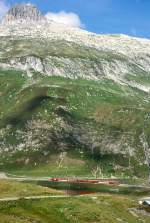 MGB FO-GLACIER-EXPRESS G 903 von Davos Platz nach Zermatt am 05.09.1997 am Oberalppass/Oberalpsee mit FO-Zahnrad-E-Lok HGe 4/4II 104 - FO PS 4013 - FO Br 4293 -  RhB B 2450 - RhB B 2423 - FO AS 4023 - RhB WR 3815. Hinweis: gut vorstellbar sind bei den hohen steilen Berghngen im Winter regelmig groe Lawinen-Abgnge. Deshalb ist hier die Bahnstrecke wo ntig, mit kilometerlangen Galerien wintersicher ausgebaut.FO-Fahrzeuge noch alte Lackierung!
