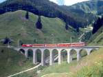 MGB FO-GLACIER-EXPRESS I 905 von St.Moritz nach Zermatt am 04.08.1992 auf Bugnei-Viadukt mit FO-Zahnrad-E-Lok HGe 4/4II 103 - FO AB - FO A - RhB B - FO B. Hinweis: Zug verkehrte bis 22.05.1993. Viadukt noch vor Umbau, FO-Fahrzeuge in alter Lackierung. Leider verdunkelte auf der linken Seite eine Wolke die Sonne.
