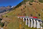 Die HGe 4/4 II 105 fährt mit dem aus Andermatt kommenden R nach Disentis über das Bugein Viadukt in Sedrun.Bild vom 5.11.2015