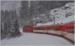 R827 mit HGe 4/4 II in herrlicher Winterlandschaft oberhalb von Dieni. (13.01.2016)