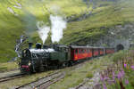 Station Furka (2160 müM): Lok HG 4/4 704 fährt mit dem Dampfzug Oberwald - Realp rückwärts in den Tunnel.