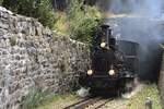 Der Kreiskehrtunnel bei Gletsch sieht fast modellbahnmässig aus. Die Passtrasse umrundet quasi das obere Portal. Hier verlässt ein Zug der Dampfbahn Furkabergstrecke am 06.09.2026 den Tunnel und fährt weiter Richtung Realp. Aufgenommen hab ich das Bild von der Mauer am Strassenrand aus.