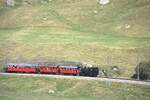 Zum Jubil�um 100 Jahre FO fuhr morgens ein Extrazug von Realp nach Andermatt um die G�ste abzuholen. Hier zwischen Realp und Hospental am 04.07.2026 im alpinen Landwirtschaftsgebiet. Andermatt hat keine Drehscheibe, daher zieht die Lok in R�ckw�rtsfahrt.