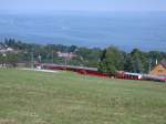 Ein Zug der RHB unterhalb Wartensee. (13.07.2003) Im Hintergrund ist der Bodensee zu sehen oder wie hier an dunstigen Tagen auch Schwbisches Meer genannt.