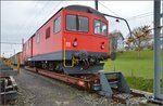 Chemins de fer de Jura (CJ). Ungewähnlicher Rollschemelverkehr mit aufgebocktem Triebwagen De 4/4 in Saignelégier. April 2016.

Dieser Gepäcktriebwagen hat eine ungewöhnliche Geschichte über mittlerweile 106 Jahre. Mangels Mitteln für eine Neubeschaffung wurden immer wieder Teile erneuert, so dass nach zahlreichen Umbauten heute wohl ein Triebwagen neueren Datums zu sehen ist, der letzte große Umbau war 1980. 