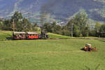 Unterhalb Kräbel auf der Arth Rigi Bahn versucht der Dampfzug mit der Stehboilerlok 7 das Brummen des Traktors zum Verteilen des gemähten Grases (zum Trocknen) zu übertönen. Dies ist auch ganz gut gelungen. 21.August 2021   