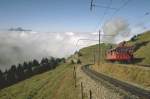 Vitznau-Rigi Bahn (VRB) Mit Volldampf auf den Gipfel,links die Gleise der ehemaligen Arth-Rigi Bahn (ARB) Heute eine Bahngesellschaft.Beide Bahngesellschaften hatten dazumal ein eigenes Trasse auf die