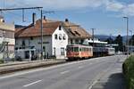 ASM BTI Aare Seeland mobil AG Biel-Täuffelen-Ins-Bahn: Be 4/4 302 + Fa 572 + Fa 571 + Fa 576 + Be 4/4 304, Zug 8250 Sutz-Finsterhennen, Lattrigen, 9. August 2021. Der zur Gleisachse querstehende Gebäudeflügel des ehemaligen Gasthofes  Landhaus  diente während Jahrzehnten auch der Bahn. 