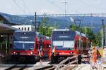 ASm BTI Aare Seeland mobil AG Biel-Täuffelen-Ins-Bahn: GTW 512 + 513, Zug 8100 Biel-Täuffelen, und GTW 505 + 510, Zug 8097 Täuffelen-Biel, Nidau, 26. Juni 2023. Der Fusswegübergang im Bild dient zugleich als einziger Zugang zum nicht behindertengerechten Mittelbahnsteig. Die Ausweiche erlaubt das  passgenaue  Kreuzen zweier  Langzüge  (also GTW + GTW, Be 2/6 + Be 2/6). Kreuzungen finden hier an Werktagen von Montag bis Freitag in den Pendlerspitzen alle 15 Minuten statt. Diese Gegebenheiten waren Auslöser, den Neubau der Station Nidau und in der Folge auch den Umbau des Niveauüberganges Hauptstrasse zu planen. Die Station wird neu zwei behindertengerechte Aussenbahnsteige erhalten. Eine Ueberdachung steht bereits. 
